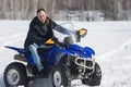 A winter forest. Cold weather. A man riding a big snowmobile