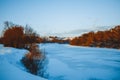 Winter forest on the river at sunset. Colorful landscape with snowy trees, Royalty Free Stock Photo