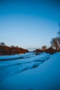 Winter forest on the river at sunset. Colorful landscape with snowy trees, Royalty Free Stock Photo