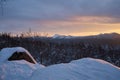 Winter forest with snow-covered fir trees high in the mountains. Dawn with bright colors on the horizon far away in the mountains Royalty Free Stock Photo