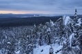 Winter forest with snow-covered fir trees high in the mountains. Dawn with bright colors on the horizon far away in the mountains Royalty Free Stock Photo