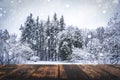 Winter forest with wooden table background. Blurred snow landscape and empty rustic table for product or merchandise. Royalty Free Stock Photo