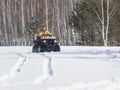 A winter forest. A young smiling woman in bright yellow jacket riding snowmobile Royalty Free Stock Photo