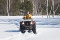 A winter forest. A young woman in yellow jacket riding snowmobile Royalty Free Stock Photo