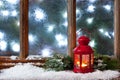 Winter frost window with burning lantern, Christmas or Advent time