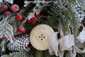 Winter frosted berries and greenery with large wooden button