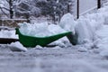 The Winter is gaining strength. A man with plastic shovel shoveling snow from driveways of home. Still snowing and snowing