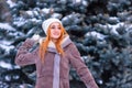 Winter ginger redhead girl throwing snowball at camera smiling happy having fun outdoors on snowing winter day playing in snow Royalty Free Stock Photo