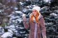 Winter ginger redhead girl throwing snowball at camera smiling happy having fun outdoors on snowing winter day playing in snow Royalty Free Stock Photo