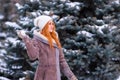 Winter ginger redhead girl throwing snowball at camera smiling happy having fun outdoors on snowing winter day playing in snow Royalty Free Stock Photo