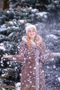 Winter ginger redhead girl throwing snowball at camera smiling happy having fun outdoors on snowing winter day playing in snow Royalty Free Stock Photo