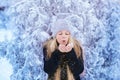 Winter girl blowing snow. Beauty Joyful Teenage Model Girl having fun in winter park. Beautiful girl laughing outdoors. Enjoying n Royalty Free Stock Photo