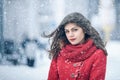 Winter. Girl brunette capless smiles on the background of snow. Close-up. hair develops