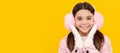 Winter girl. happy kid in winter mittens and earmuffs on yellow background, winter. Banner of christmas child girl Royalty Free Stock Photo