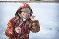 In winter, a girl in overalls caught a roach fish on the river