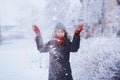 Winter girl in red gloves and scarf blowing snow. Beauty Joyful Teenage Model Girl having fun in winter park. Beautiful girl laugh Royalty Free Stock Photo