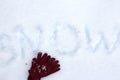 Winter gloves on snow with snow inscription. Flat lay shiny texture. . Royalty Free Stock Photo