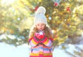 Winter happy little child holds blowing snow on hands