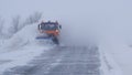 Winter. Heavy snowfall, blizzard. A special car clears the road of snow. Royalty Free Stock Photo