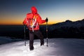 Winter hiking: man stands on a snowy ridge looking at the sunset Royalty Free Stock Photo