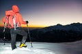 Winter hiking: man stands on a snowy ridge looking at the sunset Royalty Free Stock Photo