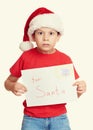 Winter holiday christmas concept - boy in hat with letter to santa on white isolated Royalty Free Stock Photo