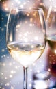 Winter holiday glasses of white wine and glowing snow on background, Christmas time romance Royalty Free Stock Photo