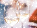 Winter holiday glasses of white wine and glowing snow on background, Christmas time romance Royalty Free Stock Photo