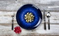 Winter holiday table setting with vintage cutlery, empty blue plate, fork, spoon and knife on white rustic wood table Royalty Free Stock Photo