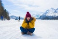 Winter holiday trip to snow valley - young happy and excited Asian Chinese woman playful on frozen lake in snowy mountains at