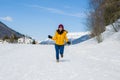 Winter holiday trip to snow valley - young happy and excited Asian Japanese woman playful on frozen lake in snowy mountains at