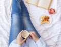 Winter holidays. Autumn morning. Woman having breakfast in bed. Coziness weekend morning. Woman with cup of coffee latte in hands Royalty Free Stock Photo