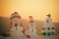 Winter holidays celebration concept. Snowmen with smiley faces in hats on evening landscape