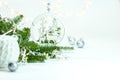 Christmas decorations with green fir tree branch and glowing garland lights against white background Royalty Free Stock Photo