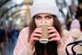 Winter holidays, christmas, hot drinks and people concept. Happy beautiful young woman tourist in warm clothes drinking coffee Royalty Free Stock Photo