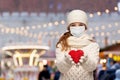 girl in mask with heart over christmas market Royalty Free Stock Photo