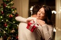 Happy couple with christmas gift hugging at home