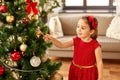 Little girl decorating christmas tree at home Royalty Free Stock Photo