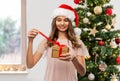 teenage girl in santa hat opening christmas gift Royalty Free Stock Photo