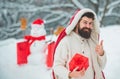 Winter holidays and people concept. Snowman and funny bearded man with gift - the friends. Happy father with Christmas