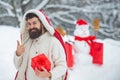 Winter holidays and people concept. Snowman and funny bearded man with gift - the friends. Happy father with Christmas