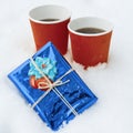 Winter holidays time snow background gift two cups of coffee Royalty Free Stock Photo