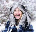 Winter holidays and vacation. Winter fashion for women. Smiling girl in plaid coat, fur hat and mittens. Closeup Royalty Free Stock Photo