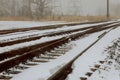 During the winter, snow covered rails of the railway can be seen in the landscape Royalty Free Stock Photo