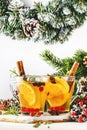 Winter hot tea with cranberry, lemon and spices in glass cup in Christmas or New Year`s table setting, white background Royalty Free Stock Photo