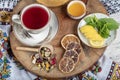 Winter hot tea with fruit, berries and spices in a cup on a table seen with cast iron teapot and herbs and dried fruits Royalty Free Stock Photo