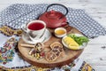Winter hot tea with fruit, berries and spices in a cup on a table seen with cast iron teapot and herbs and dried fruits Royalty Free Stock Photo