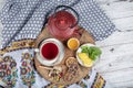 Winter hot tea with fruit, berries and spices in a cup on a table seen with cast iron teapot and herbs and dried fruits Royalty Free Stock Photo