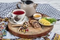 Winter hot tea with fruit, berries and spices in a cup on a table seen with cast iron teapot and herbs and dried fruits Royalty Free Stock Photo