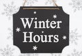 Winter Hours message on a retro hanging chalkboard with snowflakes